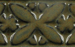 Detailed close-up of a textured ceramic tile showcasing a mottled green and brown glaze with floral patterns.