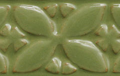 Textured green ceramic tile featuring a floral design, glazed to enhance depth, ideal for decorating pottery and sculpture.