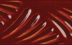 Close-up of glossy red clay glaze featuring textured wave patterns, ideal for enhancing ceramic art pieces.