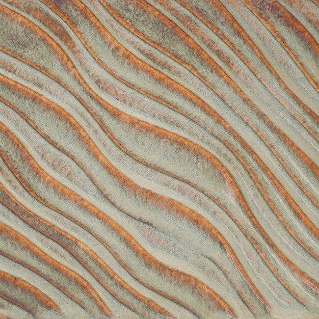 Textured ceramic surface featuring flowing lines in earthy tones of orange, blue, and beige, showcasing glaze techniques.
