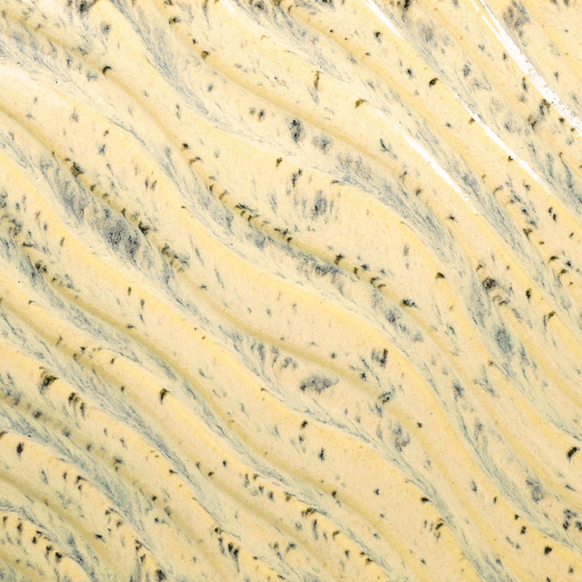 Close-up of a textured clay surface featuring creamy yellow with dark flecks, ideal for pottery and ceramic sculpting.