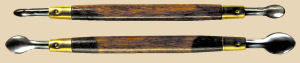 Two wooden pottery tools with metal ends, used for shaping and detailing clay in ceramics and sculpture.