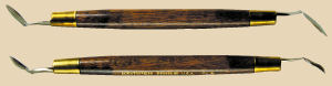 Two ceramic modeling tools with wooden handles and metal ends, used for sculpting and decorating clay pottery.