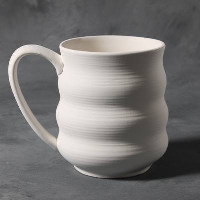 White ceramic mug with a wavy design, showcasing smooth clay texture, ready for glazing and firing.