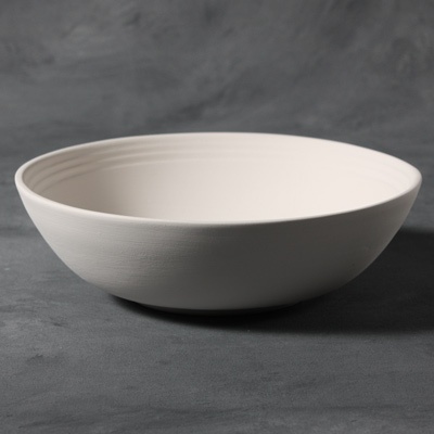 White stoneware bowl with a smooth, rounded lip and subtle ribbed detailing, ideal for glazing and firing in studio projects.