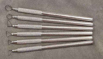 Set of six stainless steel ceramic modeling tools with textured handles, ideal for sculpting and detailing clay work.