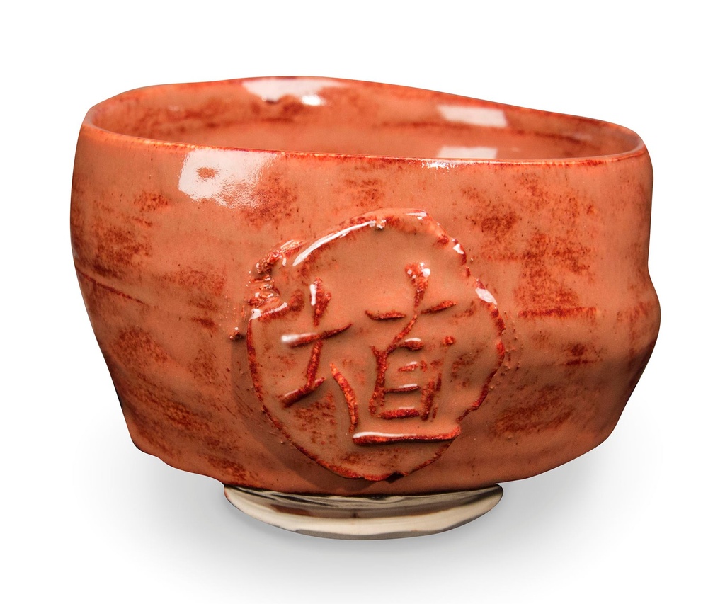 Handcrafted ceramic bowl with an orange glaze, featuring an embossed decorative design, showcasing unique pottery techniques.
