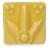 Yellow ceramic mold with floral design and three raised dots, ideal for casting decorative pottery or sculpture.