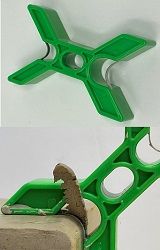 Green ceramic tool with four-pronged design, used for shaping and connecting clay pieces in pottery and sculpture.