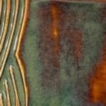 Close-up of a ceramic glaze swatch showcasing rich green and brown tones with textured lines, ideal for pottery finishes.