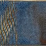 Textured blue glaze sample with wavy gold accents, showcasing a ceramic surface ideal for pottery decoration.