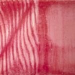 Textured red ceramic glaze sample showcasing a glossy finish and striped patterns, ideal for pottery decoration.