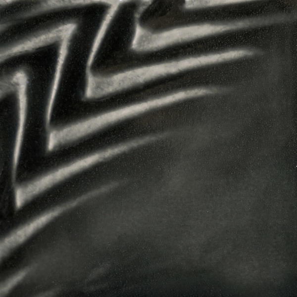 Textured black clay surface with a glossy finish, showcasing zigzag patterns, ideal for pottery decoration or sculpture work.