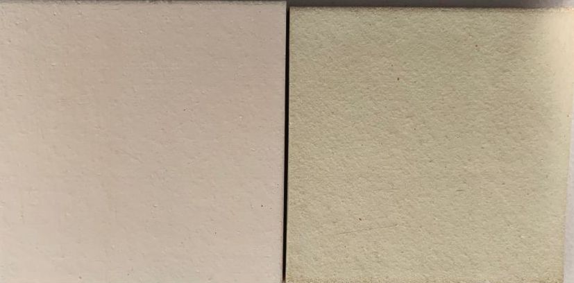 Two square clay test tiles side by side, one a light beige color and the other a pale yellow, for glaze evaluation.