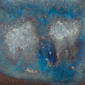 Close-up of a ceramic glaze sample featuring vibrant blue and white tones with speckled textures, ideal for pottery decoration.