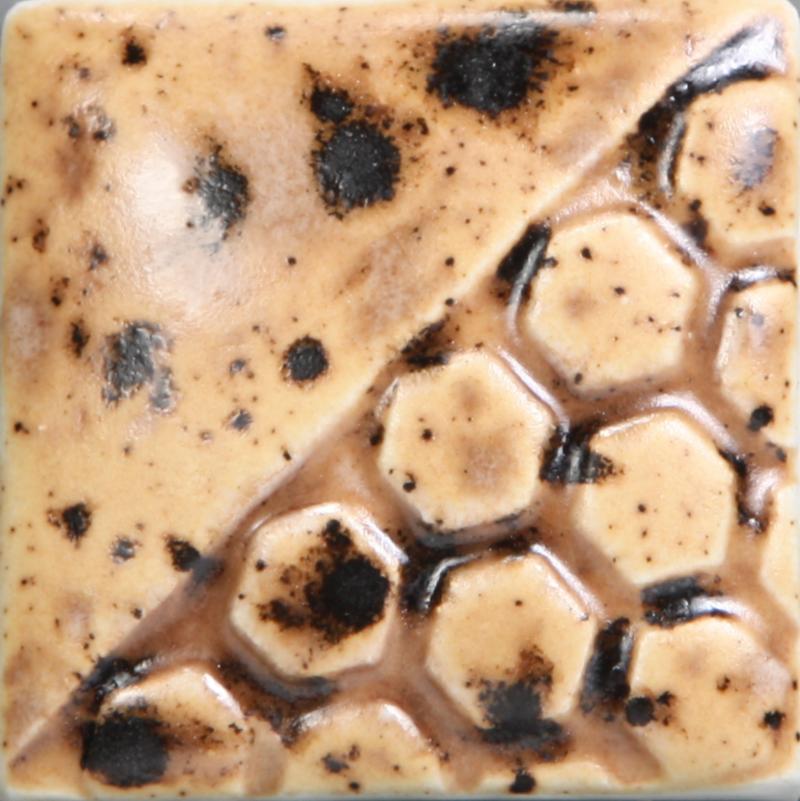 Textured ceramic tile featuring a honeycomb pattern with speckled brown and beige glazes, showcasing unique surface variations.