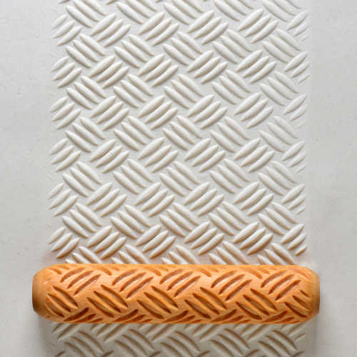 Textured clay sheet with a patterned roller, demonstrating pottery design techniques for ceramics and sculpture projects.