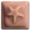 Star-shaped pink clay tile with a glossy glaze, showcasing texture and design for pottery decoration and sculpting.