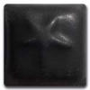 Glossy black clay test tile featuring an embossed design, used for evaluating glazes and ceramic techniques.