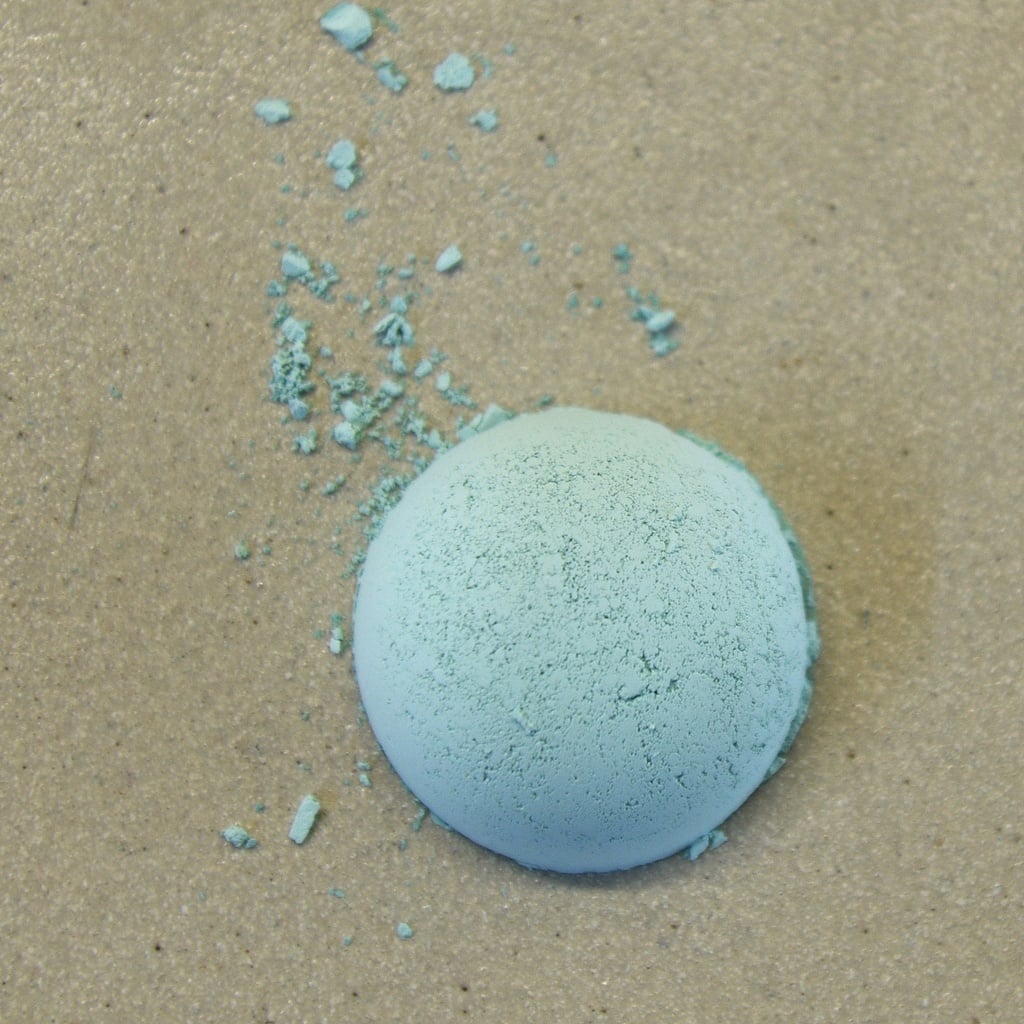 Light blue ceramic glaze powder scattered on a textured surface, showing the fine grain and color for pottery applications.