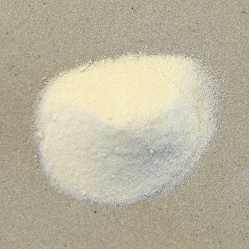 Fine yellow ceramic glaze powder on a textured surface, used for decorating pottery and firing in kilns at Georgies.