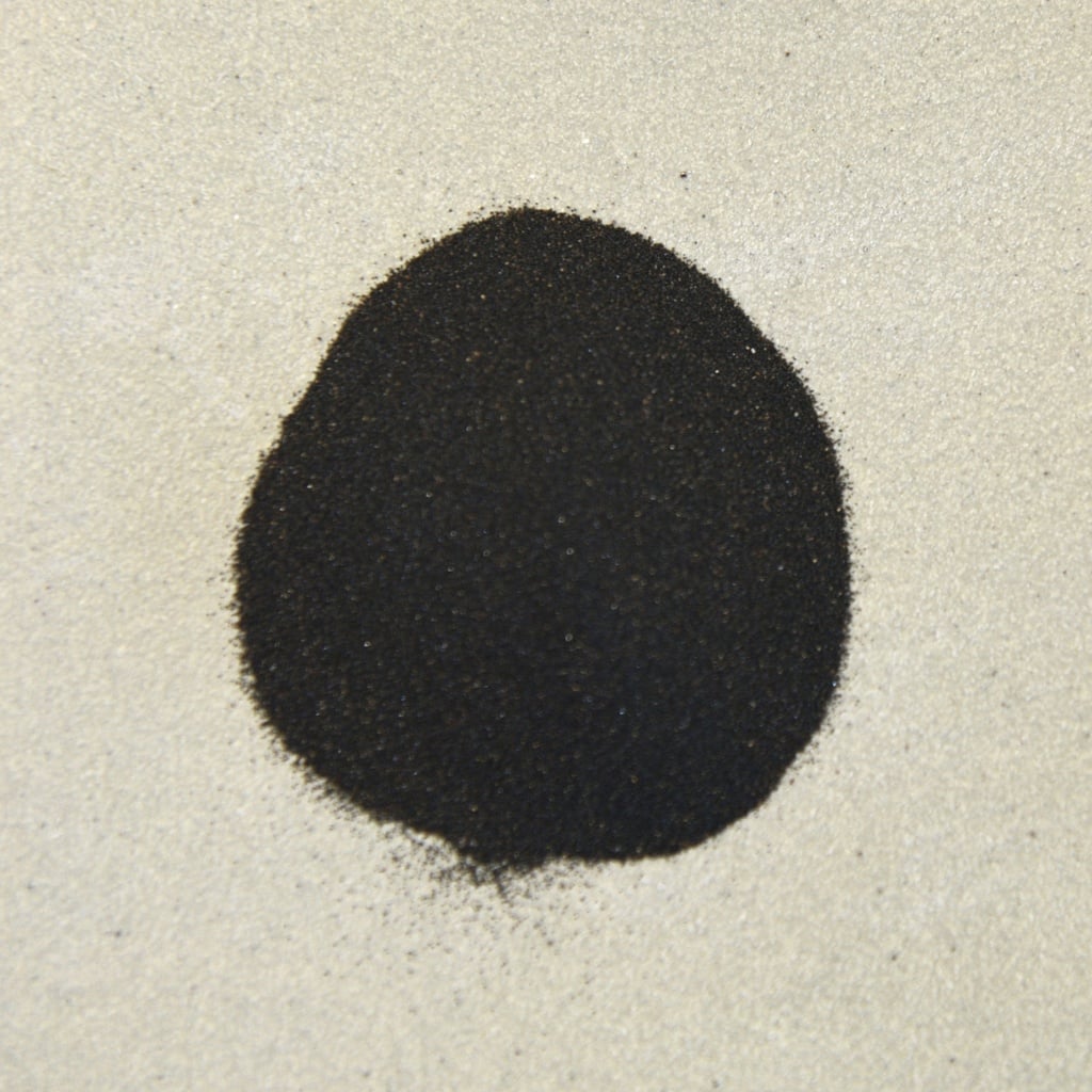 Fine black clay powder sits on a light surface, ideal for ceramic glazes and decorative techniques at Georgies Ceramic & Clay Company.