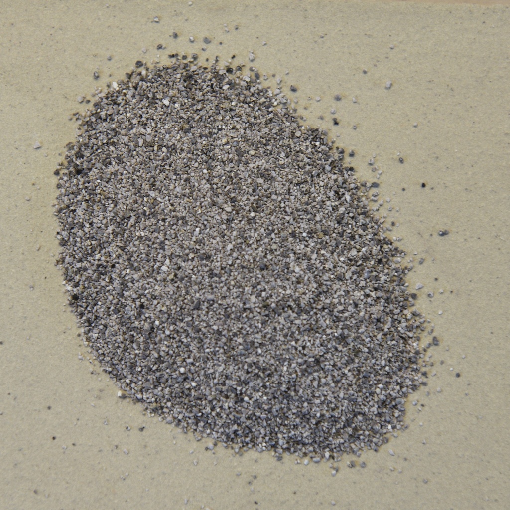 Crushed gray clay and stone aggregate spread on a light surface, ideal for creating textured ceramic sculptures.